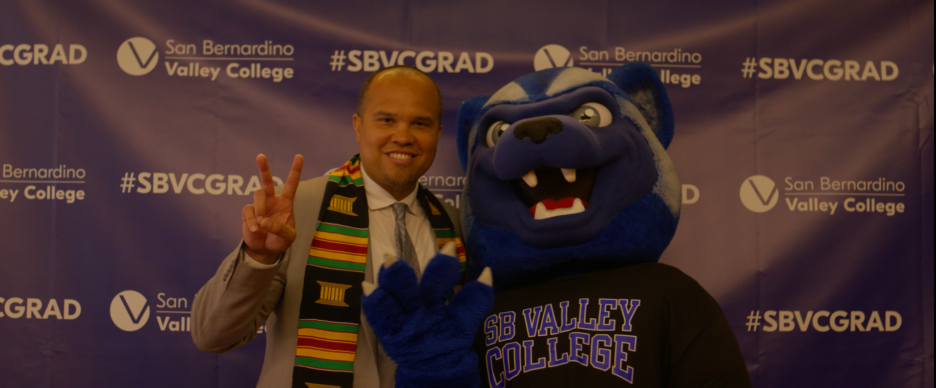 Dr. Scott Thayer smiling with Blue the Wolverine