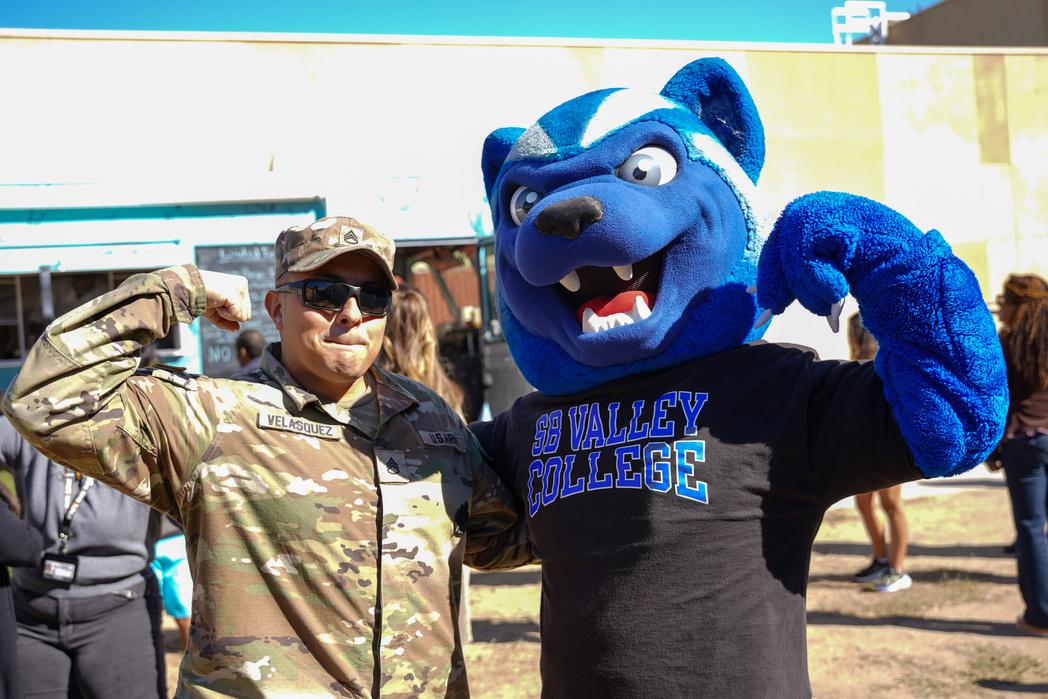 Blue the mascot and a veteran flexing for the camera