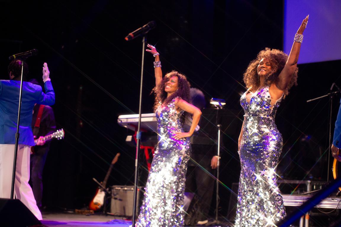 Two women singers in sequin dresses posing