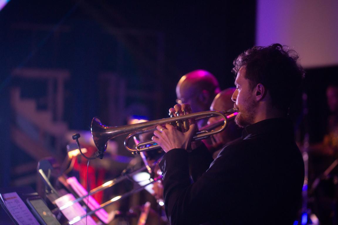 A horn player accompanying the bad  