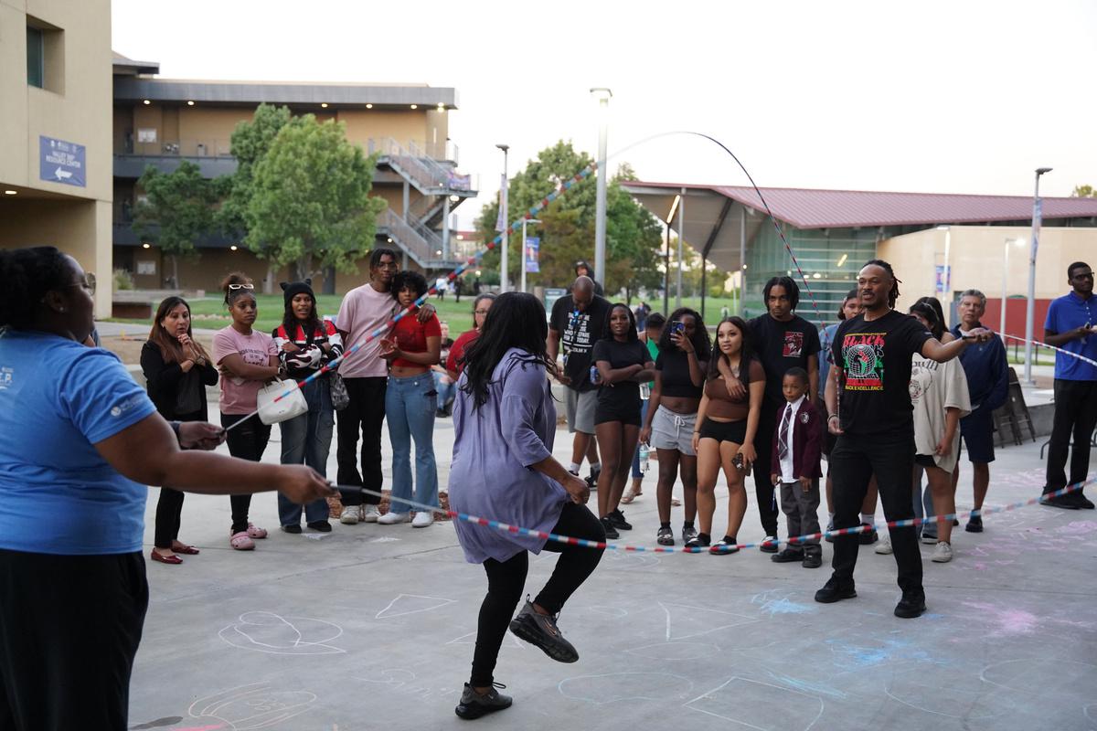 Students surround a girl jumping rope