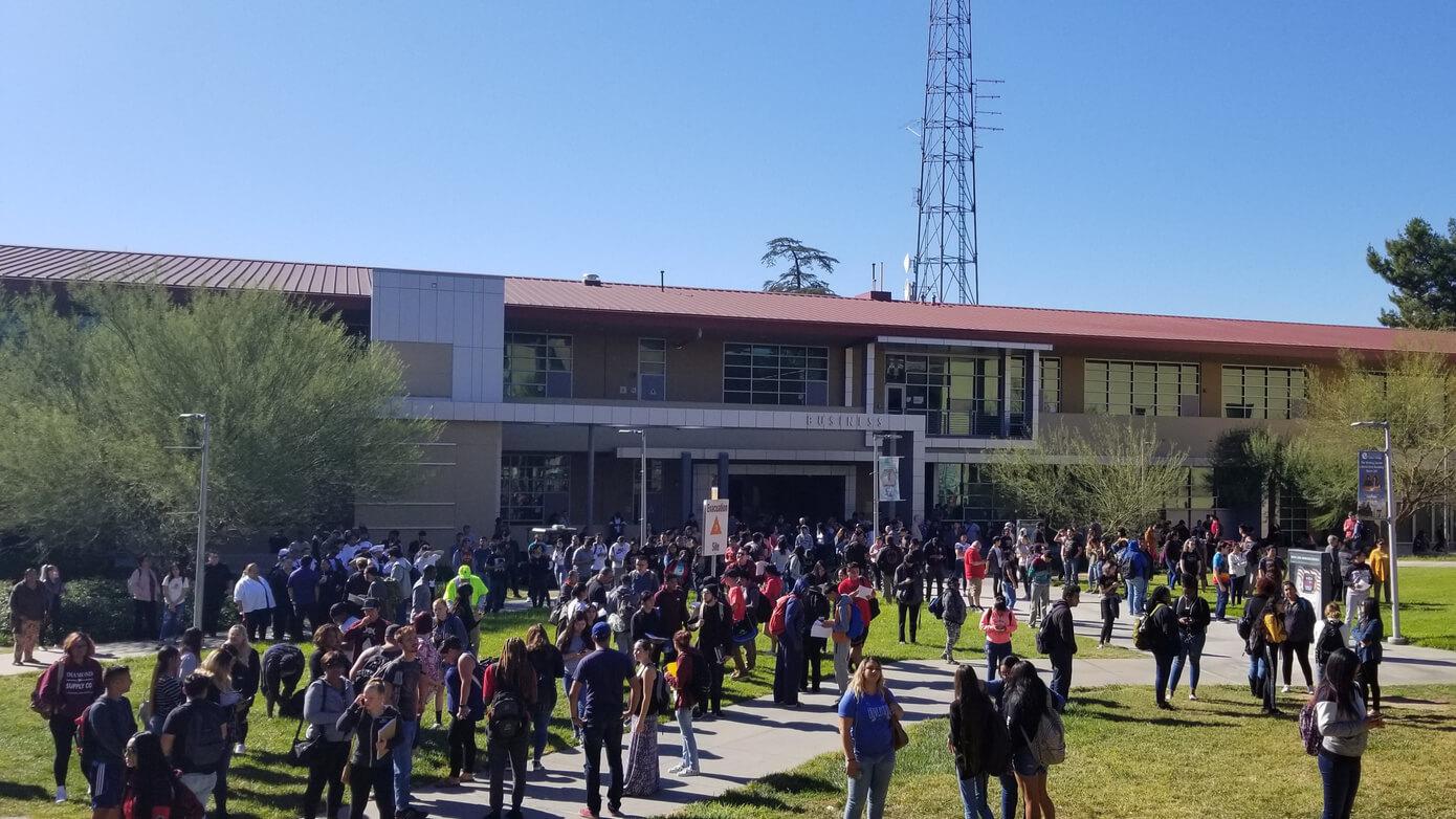 Students walking and gathering in the grassy area outside of the SBVC Business building